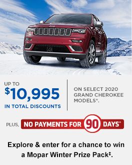 Image of red Jeep Grand Cherokee in wintry mountain scene.